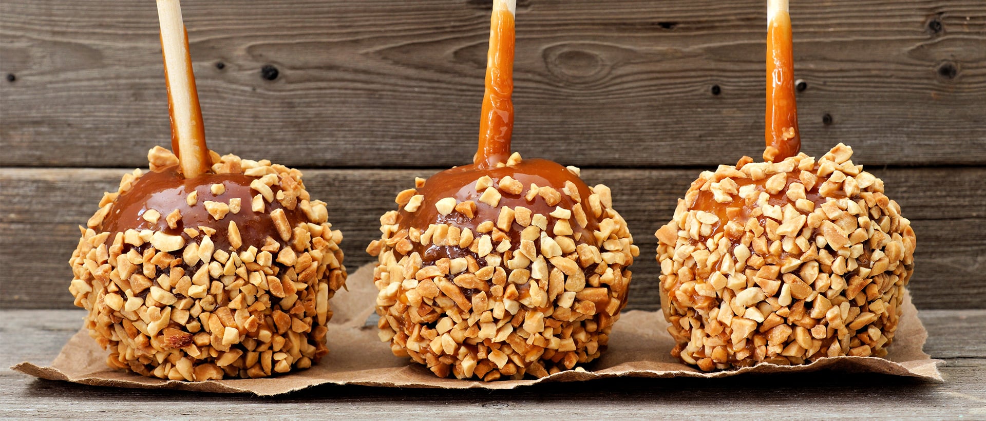 three caramel apples with nuts