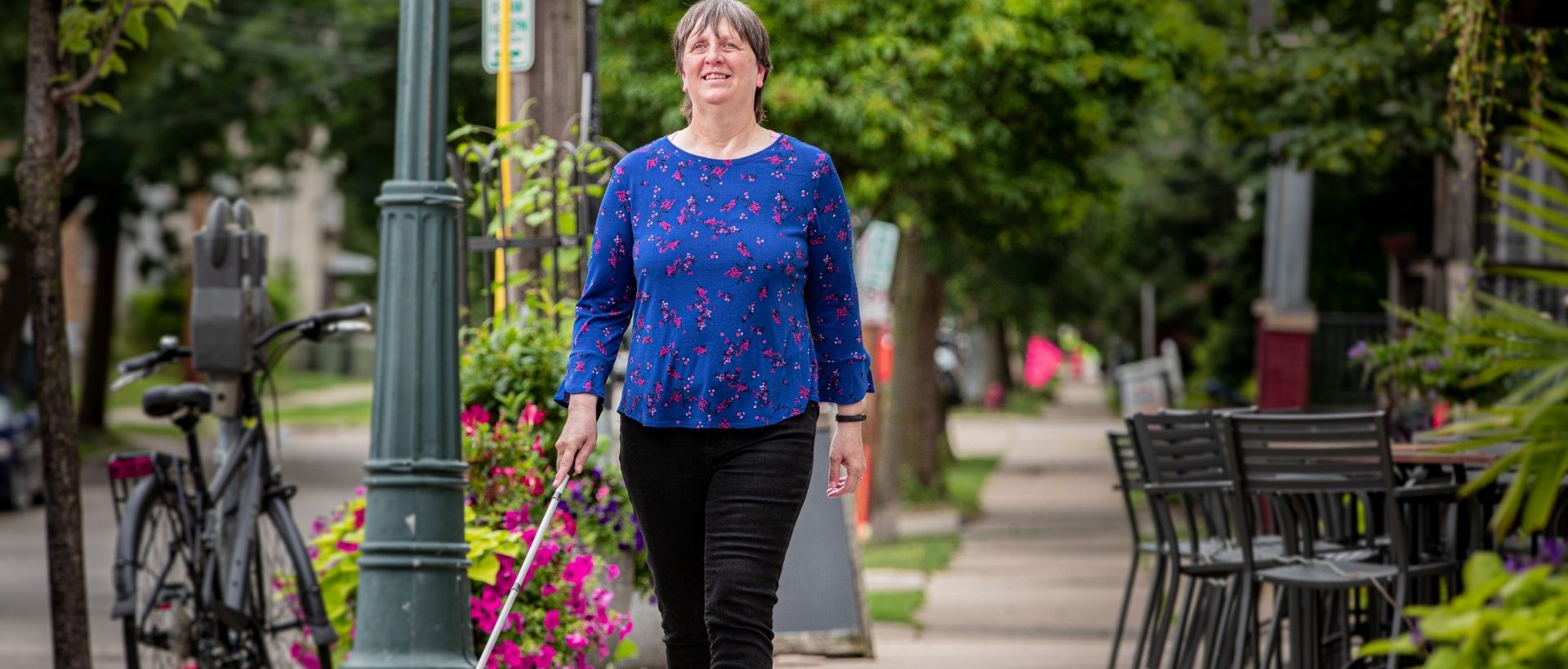 Woman walking down a city street with a cane