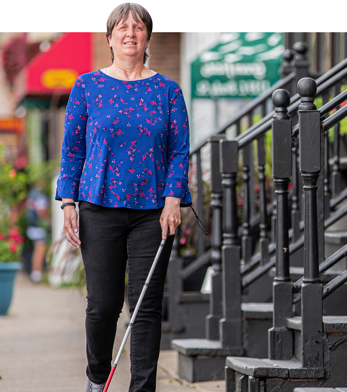 Woman walking down a city street with a cane