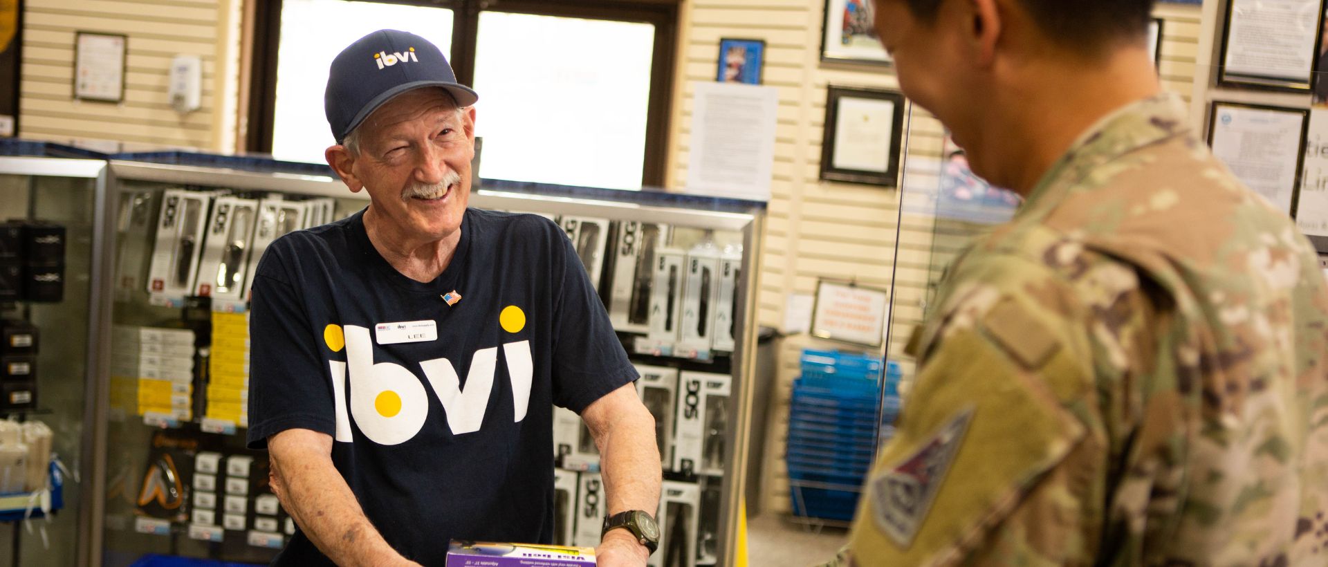 Man in IBVI t-shirt talking with a customer