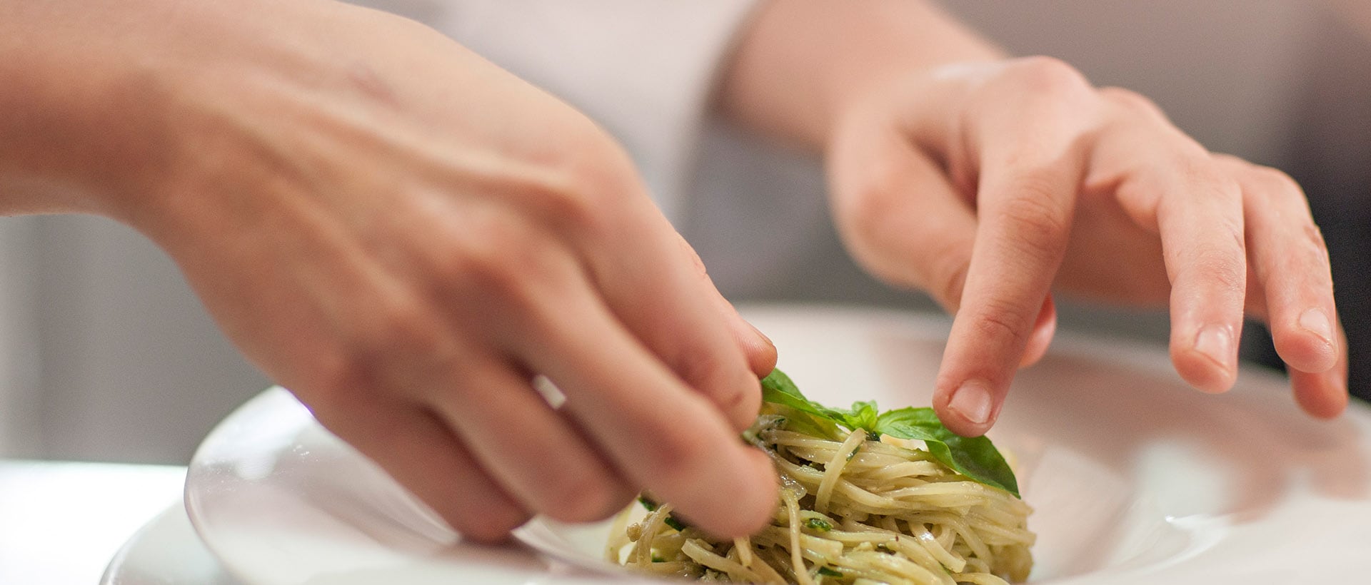 closeup of hands plating a meal