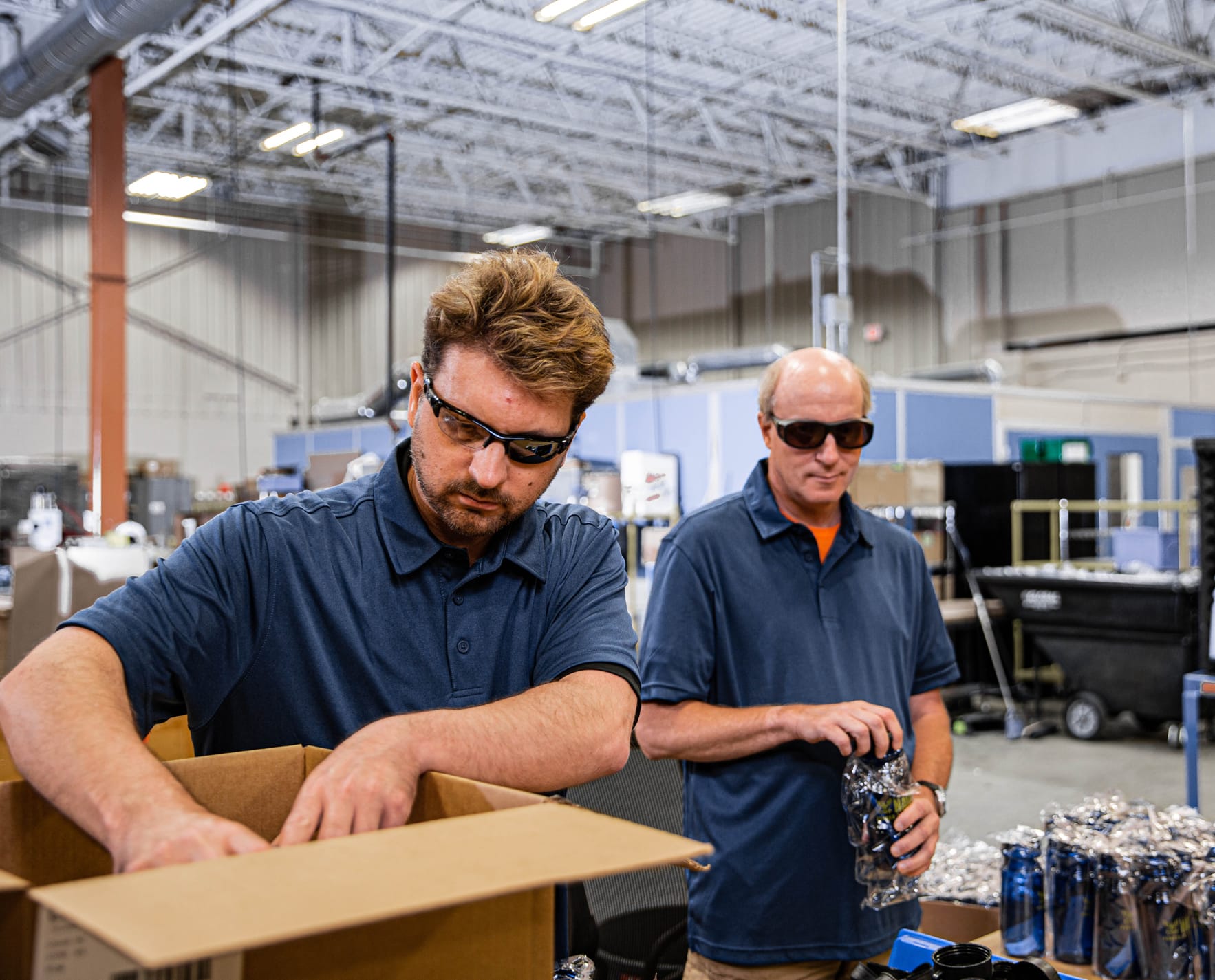 Two men with sunglasses working in a warehouse