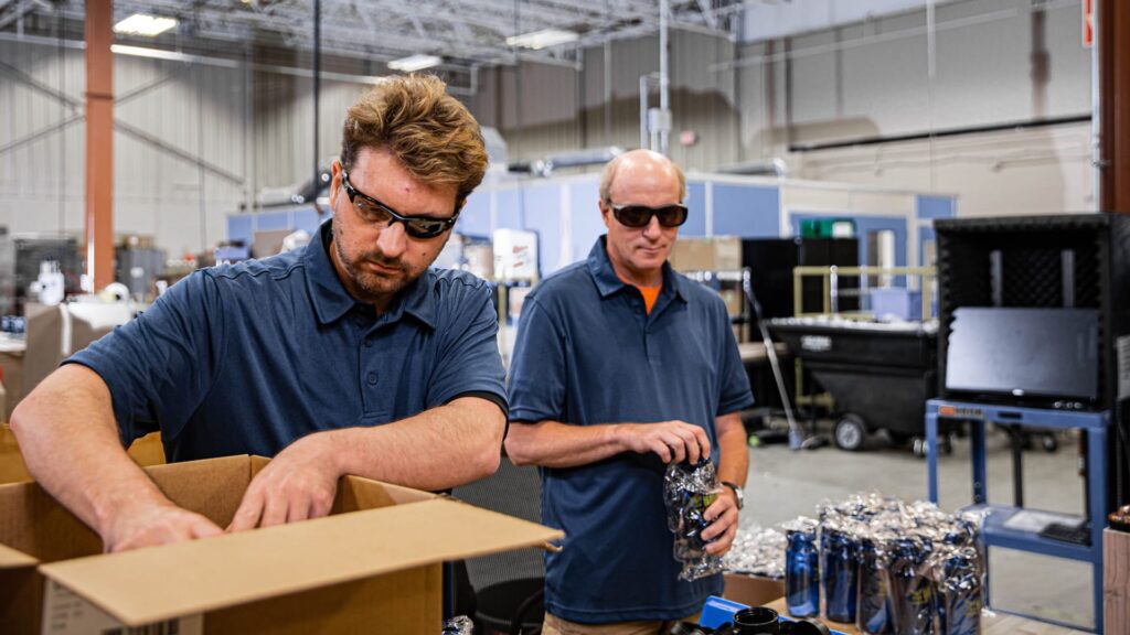 Two men with sunglasses working in a warehouse